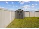 Backyard storage shed offering additional space for tools and equipment, surrounded by green grass and a privacy fence at 9440 Lemon Drop Loop, Sun City Center, FL 33573