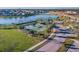 Aerial view of a community tennis court, near a pond, with lush landscaping and palm trees at 9440 Lemon Drop Loop, Sun City Center, FL 33573