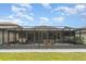 Wide shot of backyard with screened patio, outdoor seating, and a lush green lawn at 9514 Channing Hill Dr, Sun City Center, FL 33573