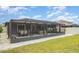 Expansive backyard with screened patio, outdoor dining, and a beautifully landscaped lawn at 9514 Channing Hill Dr, Sun City Center, FL 33573