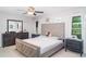 Serene bedroom with a tufted headboard, coordinating furniture, and natural light from the windows at 9514 Channing Hill Dr, Sun City Center, FL 33573