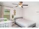 Bedroom featuring a crib next to a bed and a window at 9514 Channing Hill Dr, Sun City Center, FL 33573
