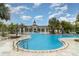 Beautiful community pool and clubhouse are surrounded by lush tropical landscaping and mature trees at 9514 Channing Hill Dr, Sun City Center, FL 33573