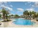Large community pool with an attached spa, and plenty of seating and palm trees at 9514 Channing Hill Dr, Sun City Center, FL 33573