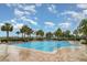 Large community pool with lounge chairs and ample palm trees at 9514 Channing Hill Dr, Sun City Center, FL 33573