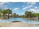 Resort-style community pool with fountains, lounge chairs, and lush tropical landscaping at 9514 Channing Hill Dr, Sun City Center, FL 33573