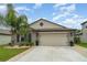 Beautiful home with a well manicured lawn, two-car garage and mature tropical trees at 9514 Channing Hill Dr, Sun City Center, FL 33573