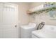 Well-lit laundry area equipped with shelving, a utility sink, a washer and a dryer at 9514 Channing Hill Dr, Sun City Center, FL 33573