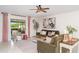 Bright living room with ceiling fan, stylish furniture, and sliding glass doors leading to a patio at 9514 Channing Hill Dr, Sun City Center, FL 33573