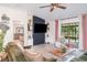 Cozy living room with a brick accent wall, mounted TV, and sliding glass doors to the patio at 9514 Channing Hill Dr, Sun City Center, FL 33573
