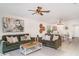 Inviting living room featuring comfortable green sofas, stylish decor, and a ceiling fan at 9514 Channing Hill Dr, Sun City Center, FL 33573