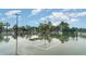 Tennis court surrounded by green fencing and trees at 9514 Channing Hill Dr, Sun City Center, FL 33573
