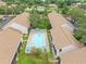 Aerial view featuring a community pool surrounded by residential buildings, manicured lawns, and mature trees at 9804 Lombard Ct # 104, Tampa, FL 33618