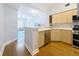 Open kitchen with light wood cabinets, stainless steel appliances, and a view into the living room at 100 4Th S Ave # 312, St Petersburg, FL 33701