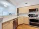Modern kitchen with light wood cabinets, wine rack, stainless steel appliances, and granite countertops at 100 4Th S Ave # 312, St Petersburg, FL 33701
