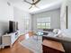 Living room featuring a grey sectional sofa, ceiling fan and view of the balcony at 100 4Th S Ave # 312, St Petersburg, FL 33701