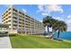 Low angle exterior of building with waterfront access and lush green lawn at 100 Bluff View Dr # 308A, Belleair Bluffs, FL 33770