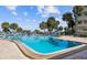 Community pool with lounge chairs and palm trees at 100 Bluff View Dr # 308A, Belleair Bluffs, FL 33770