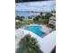 Scenic pool area with palm trees, lounge chairs, and water views at 100 Bluff View Dr # 308A, Belleair Bluffs, FL 33770