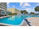 Large community pool with lounge chairs and beautiful landscaping at 100 Bluff View Dr # 308A, Belleair Bluffs, FL 33770
