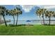 Green lawn with views, perfect for relaxing near the water with a table and chairs under swaying palm trees at 100 Bluff View Dr # 308A, Belleair Bluffs, FL 33770