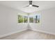 Sunlit bedroom featuring wood-look tile floors and large windows with views of lush greenery at 109 13Th St, Belleair Beach, FL 33786