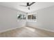 Bright bedroom featuring wood-look tile floors and large windows with views of lush greenery at 109 13Th St, Belleair Beach, FL 33786