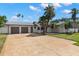 Beautiful single-story home featuring a two-car garage and a spacious patterned driveway at 109 13Th St, Belleair Beach, FL 33786