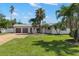 Charming single-story home with a well-manicured lawn and mature palm trees at 109 13Th St, Belleair Beach, FL 33786