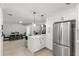 Open kitchen with stainless steel appliances, bar seating, and seamless flow into dining area at 109 13Th St, Belleair Beach, FL 33786