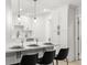 Bright kitchen featuring a white quartz breakfast bar, shaker cabinets, and modern pendant lights at 109 13Th St, Belleair Beach, FL 33786