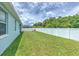 A spacious backyard showcasing the lush lawn and a white privacy fence, offering a serene outdoor space at 11336 Callaway Pond Dr, Riverview, FL 33579
