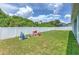 Spacious backyard with a white fence, lush green lawn, and a play set at 11336 Callaway Pond Dr, Riverview, FL 33579