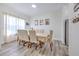 Bright dining room with neutral tones, showcasing a large table, linen chairs and decorative accents at 11336 Callaway Pond Dr, Riverview, FL 33579