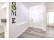 Inviting foyer featuring light gray floors and a modern workstation, enhanced by the charming 'HOME' decor at 11336 Callaway Pond Dr, Riverview, FL 33579