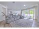 Bright, open living room with modern furniture, light hardwood floors, and sliding glass doors to the patio at 11336 Callaway Pond Dr, Riverview, FL 33579