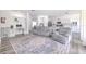 Comfortable living room with open floor plan features gray sofas, a workstation, and access to the kitchen at 11336 Callaway Pond Dr, Riverview, FL 33579