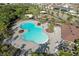 Aerial view of a community pool with lounge chairs, tables, and lush landscaping, perfect for relaxation and recreation at 11336 Callaway Pond Dr, Riverview, FL 33579