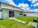 Backyard featuring green grass, stepping stones to a sliding door, and a privacy fence at 12121 Tree Haven Ave, Gibsonton, FL 33534