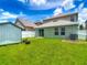 Backyard featuring green grass, stepping stones to a sliding door, shed, and privacy fence at 12121 Tree Haven Ave, Gibsonton, FL 33534