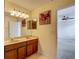 Bathroom featuring a double vanity with wood cabinets and framed mirrors, plus decorative artwork at 12121 Tree Haven Ave, Gibsonton, FL 33534