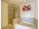 Bright bathroom featuring a garden tub, stand up shower with glass doors and decorative artwork at 12121 Tree Haven Ave, Gibsonton, FL 33534
