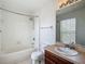 Bathroom features a shower over tub, vanity with wood cabinets, and tile flooring at 12121 Tree Haven Ave, Gibsonton, FL 33534