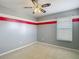 Bedroom with fan and neutral carpet with gray walls and red stripe accent at 12121 Tree Haven Ave, Gibsonton, FL 33534