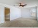 Spacious bedroom with white walls, ceiling fan, carpet flooring, and a window providing natural light at 12121 Tree Haven Ave, Gibsonton, FL 33534