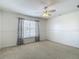 Bright bedroom with a neutral carpet, ceiling fan, and natural light from the window at 12121 Tree Haven Ave, Gibsonton, FL 33534