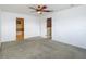 Neutral bedroom with an ensuite bathroom, ceiling fan, and carpet flooring at 12121 Tree Haven Ave, Gibsonton, FL 33534