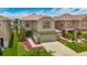 Two-story home featuring a two-car garage, manicured lawn, and beautiful landscaping at 12121 Tree Haven Ave, Gibsonton, FL 33534
