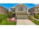 Two-story home featuring a two-car garage, manicured lawn, and beautiful landscaping at 12121 Tree Haven Ave, Gibsonton, FL 33534