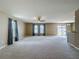 Spacious living room featuring neutral paint, large windows, and adjacent kitchen at 12121 Tree Haven Ave, Gibsonton, FL 33534